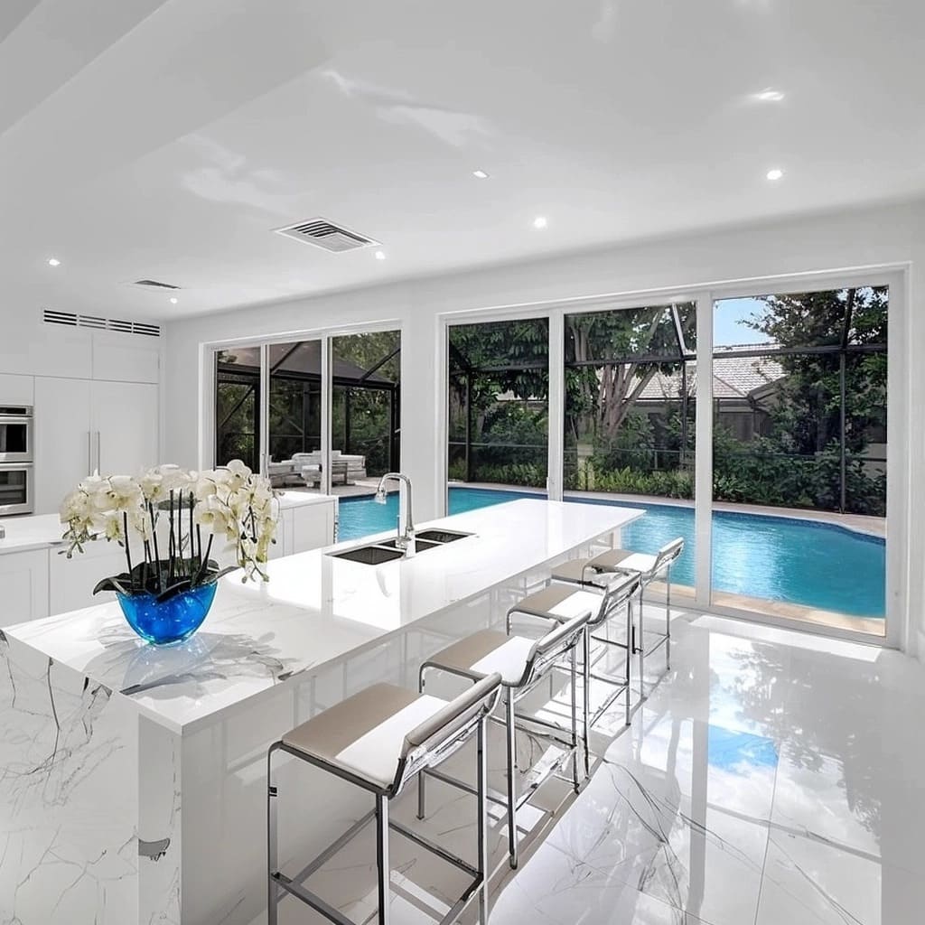 This interior exudes a minimalist and luxurious style, where the marble dining table and kitchen island make a bold statement.jpg