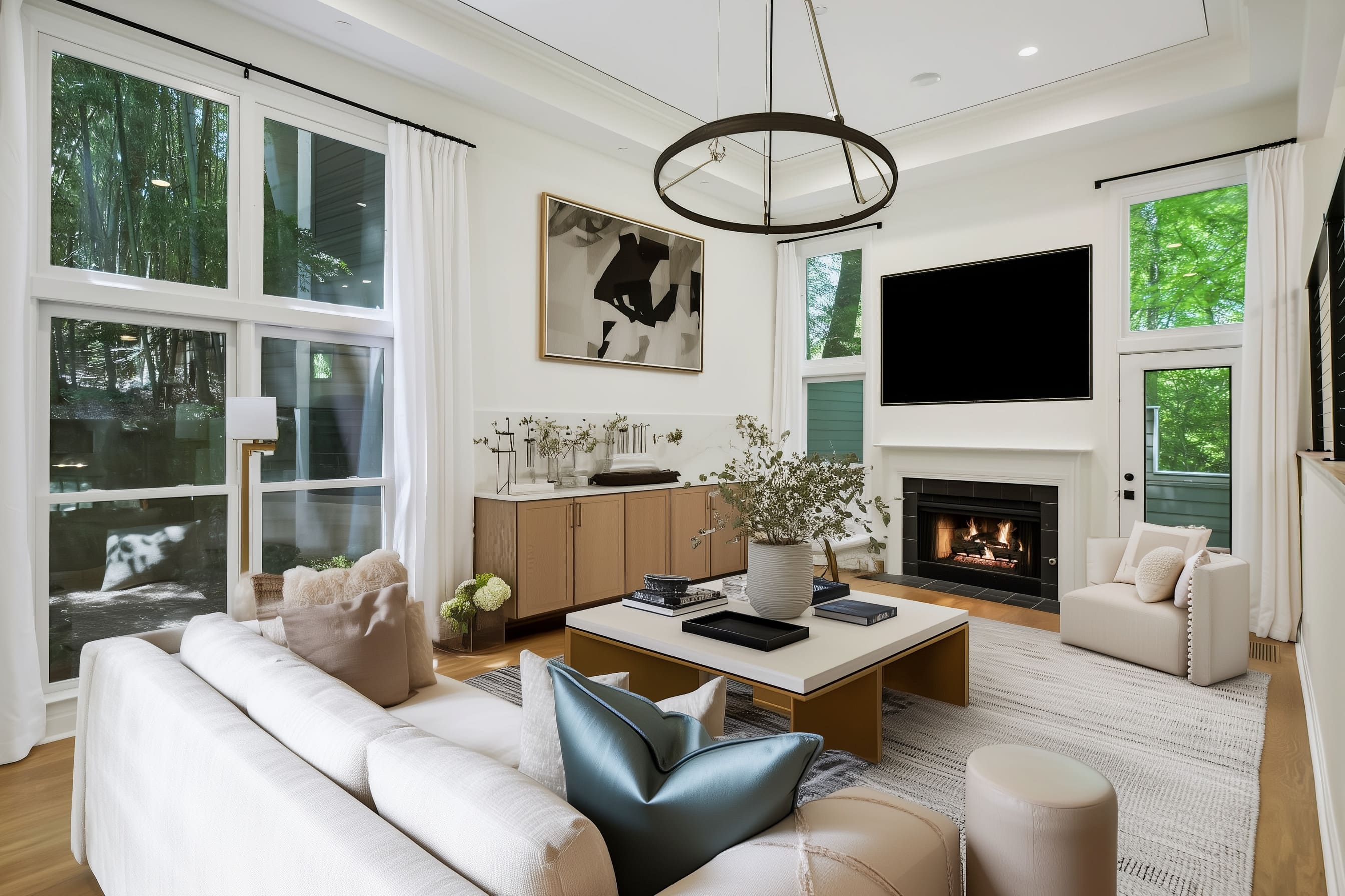 The room centers around a wide square coffee table with a two-tone design a creamy stone-colored top and warm bronze base, which balances structure and lightness