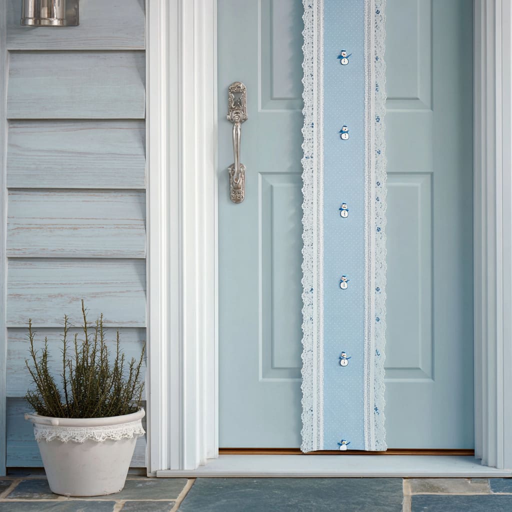 A soft coastal-blue door accented by a pale blue fabric stripe with tiny snowman appliques, framed with white lace, paired with silver hardware A soft coastal-blue door accented by a pale blue fabric stripe with tiny snowman appliques, framed with white lace, paired with silver hardware